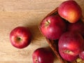 Top view of juicy red organic apples in a basket on oak tree wood background. Autumn Fall season orchard harvest production. Royalty Free Stock Photo