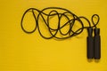 Top view of a jump rope on the yellow mat. Sport at home, fitness practice