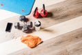 Top view Kettlebells, foar roller, dumbbells, a bottle, a towel and a cell phone