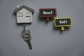 Top view of key holder with key and wooden notice board with question rent or sell Royalty Free Stock Photo