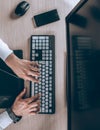 Top view of keyboard with men`s hands. Free black monitor copy space for design Royalty Free Stock Photo