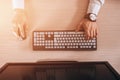 Top view of keyboard with men`s hands. Free black monitor copy space for design. Warm glare of sun light Royalty Free Stock Photo