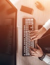 Top view of keyboard with men`s hands. Free black monitor copy space for design. Warm glare of sun light Royalty Free Stock Photo