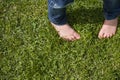 Top view on kid`s bare feet on the green grass. Little boy standing on the grass in the park on a sunny day Royalty Free Stock Photo