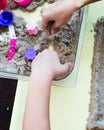 Top view of kinetic sands in a container on the table with a children playing. Selective focus Royalty Free Stock Photo