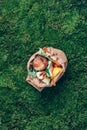 Top view. Kitchen food waste collected in craft paper bag. Peeled vegetables on green grass, moss background