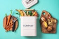 Top view of kitchen food waste collected in recycling compost pot. Peeled vegetables on chopping board, white compost bin on blue