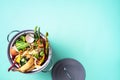 Top view of kitchen food waste collected in recycling compost pot. Peeled vegetables on chopping board, white compost bin on blue Royalty Free Stock Photo