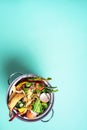 Top view of kitchen food waste collected in recycling compost pot. Peeled vegetables on chopping board, white compost bin on blue Royalty Free Stock Photo