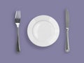 Top view of knife, plate and fork on violet