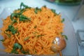 Top view of Korean-style carrots Koryo-saram, spicy pickled carrot in bowl . Salad with fresh carrot and oil . Raw Organic Orange