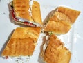 Top view of labneh sandwiches on a white plate. Creamy yoghurt spread on bread, with tomatoes and olives