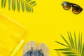 Top view lady`s things for beach, sunglasses and slippers. Flat lay frame with space for banner decorated with palm tree