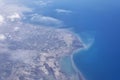 Top view from landing airplane. Window plane with copy space. Aerial view of cloud, sea, ocean and city landscape Royalty Free Stock Photo