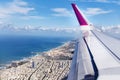 Top view from landing airplane. Window plane with copy space. Aerial view of cloud, sea, ocean and city landscape Royalty Free Stock Photo