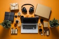 Top view of laptop, headphones, gift boxes and cups of coffee on yellow background. Cyber Monday, Black Friday