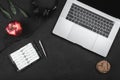 Top view of laptop and headphones, notebook and pen, red apple on a black table Royalty Free Stock Photo