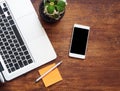 Top view of laptop keyboard, orange sticker with pen and cellphone on the wooden table Royalty Free Stock Photo