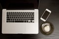 Top view of a laptop keyboard, smartphone and dessert on a black wooden table Royalty Free Stock Photo