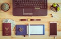 Top view of laptop, notebook, pen, passport, money, mobile phone