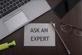 Top view of laptop, phone, glasses and pencil with card ask and expert. Business concept Royalty Free Stock Photo