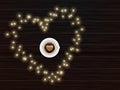 Top View of Latte Art Love Coffee Cup on Heart Shape Made by Lighting Garland with Brown Wooden Background