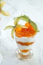 Top view of layered dessert with protein yoghurt and physalis fruit in a glass jar, on marble table Royalty Free Stock Photo