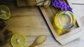 Top view lemon honey tea mixed with ginger in a clear glass, with a spoon and  brown sugar and hemp bag placed in a wooden tray on Royalty Free Stock Photo