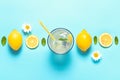 Top view of limonade and lemon slices on blue background with copyspace