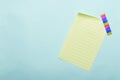 Top view of lined yellow sheet of paper and colorful tape on the blue blank surface Royalty Free Stock Photo