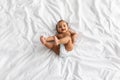 Top view of little black baby lying on bed at home Royalty Free Stock Photo