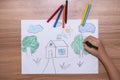 Top view of a little boy drawing a house with crayons is a beautiful imagination painting. A child`s hand is engaged in creativit Royalty Free Stock Photo