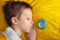 Top view of little boy sleeping in yellow bed with alarm clock near his head Royalty Free Stock Photo