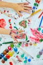 Top view Little girl with painted colorful watercolor hands, child sitting at the table and drawing, Royalty Free Stock Photo