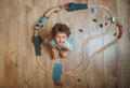 Top view of little kid boy playing wooden train set. Child sitting on floor with toys. Toys for little boy. Preschooler Royalty Free Stock Photo