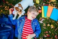 Top view of little school boy pupil lying on the grass with colorful books, apple, backpack Royalty Free Stock Photo