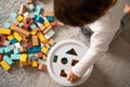 Top view of little toddler boy playing with wooden colorful building blocks sorting shapes