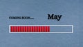 Top view of loading bar with text - Coming soon May. Light blue background. Royalty Free Stock Photo
