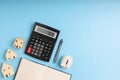 Top view LOAN on the black calculator with little home models, notebook, and white piggy bank on blue background with copy space. Royalty Free Stock Photo
