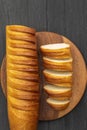 Top view of a long-shaped fresh white bread that lies on a black wooden background Royalty Free Stock Photo