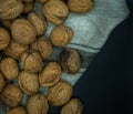 Top view of a lot of walnuts on kitchen cloth, black background, healthy food concept Royalty Free Stock Photo