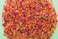 Top view of lots of bright colorful plastic beads on light green background