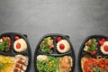 Top view of lunchboxes with different meals on grey table. Healthy food delivery Royalty Free Stock Photo