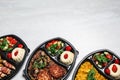 Top view of lunchboxes with different meals on white table. Healthy food delivery