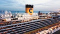 Top view of the luxury cruise ship upper deck near the pier with many people on board relaxing, playing basketball and