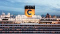 Top view of the luxury cruise ship upper deck near the pier with many people on board relaxing, playing basketball and