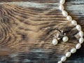 Top view of Luxury pearl necklace and pearl earrings on old wooden table. with copy space, close up