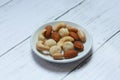 Top view of macadamia,cashew,almond and peanuts nuts in bowl on wooden background. Royalty Free Stock Photo