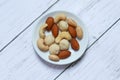 Top view of macadamia,cashew,almond and peanuts nuts in bowl on wooden background. Royalty Free Stock Photo