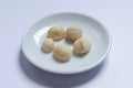 Top view of macadamia nuts in bowl on white background. Royalty Free Stock Photo